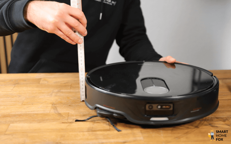 Der Roborock Qrevo Slim wird mit einem Lineal ausgemessen.